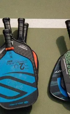 Two paddles resting against the net post between games