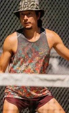 A player in a bucket hat waiting at the net between points